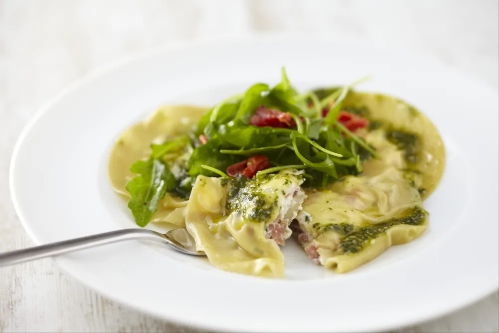 Raviole de jambon de pays et chèvre frais, pesto et roquette