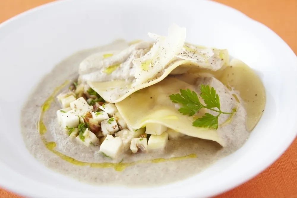 Ravioles de foie gras à l'huile de truffe blanche, crème de champignons aux noisettes, copeaux de parmesan