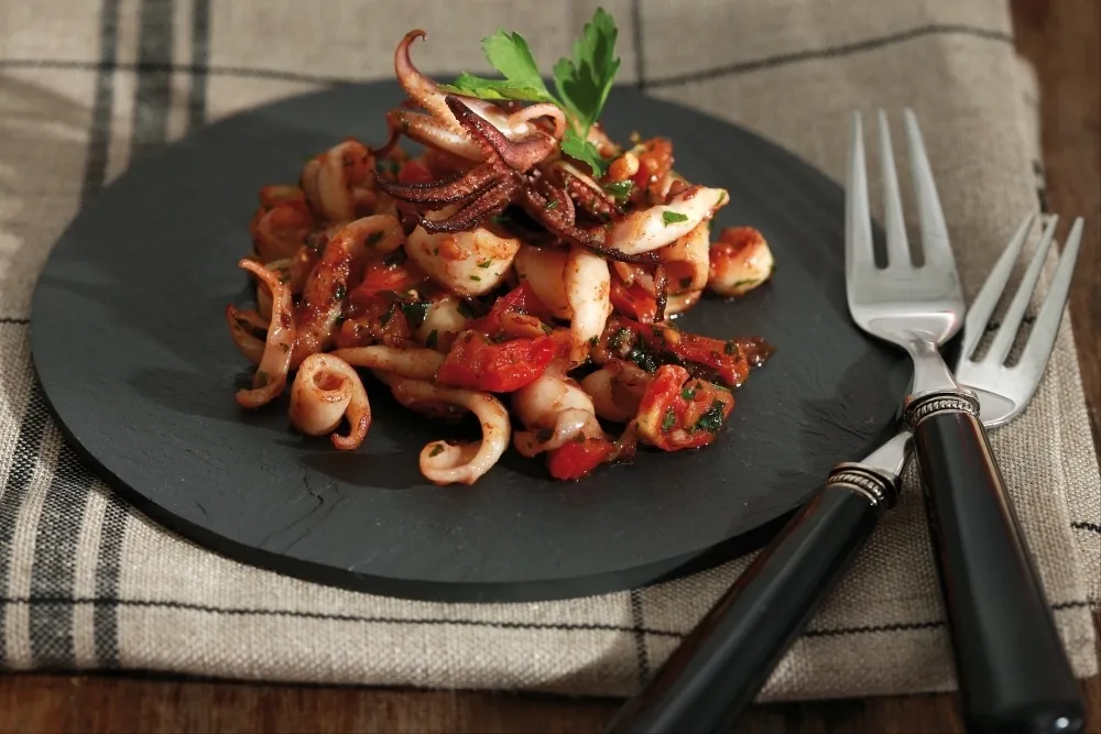 Calamars à la plancha, tomates confites, ail et persil