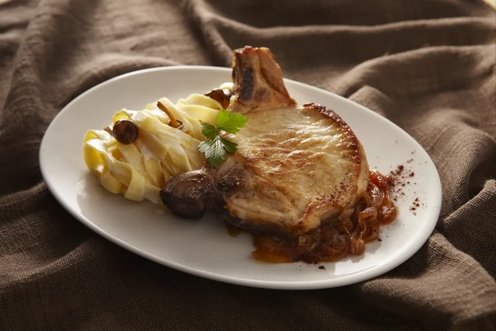 Côtes de porc aux oignons caramélisés et pâtes fraîches